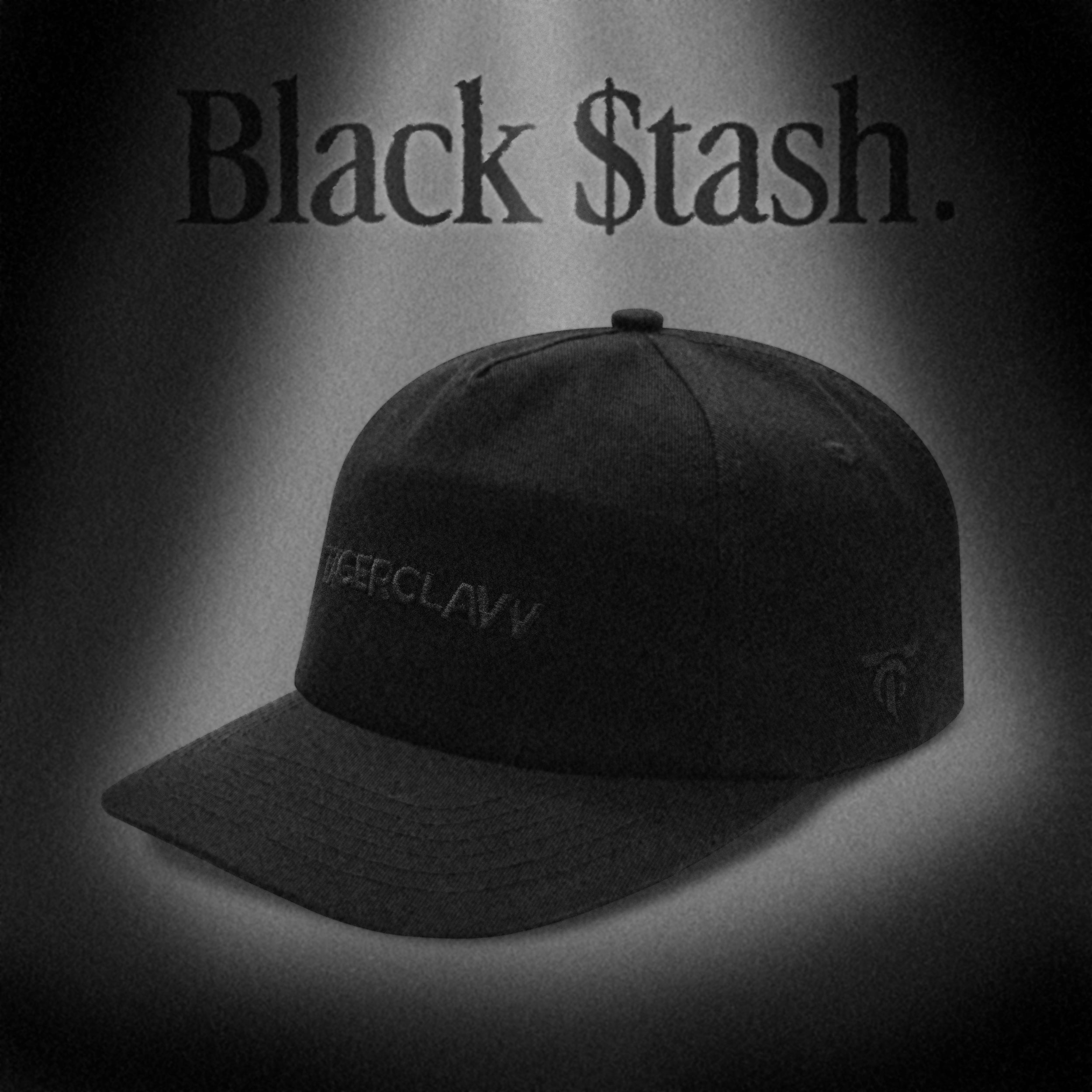 Minimal black cap with subtle embroidered Tigerclaw logo on the front and side, presented in a moody monochrome “Black $tash” campaign graphic with spotlight effect.