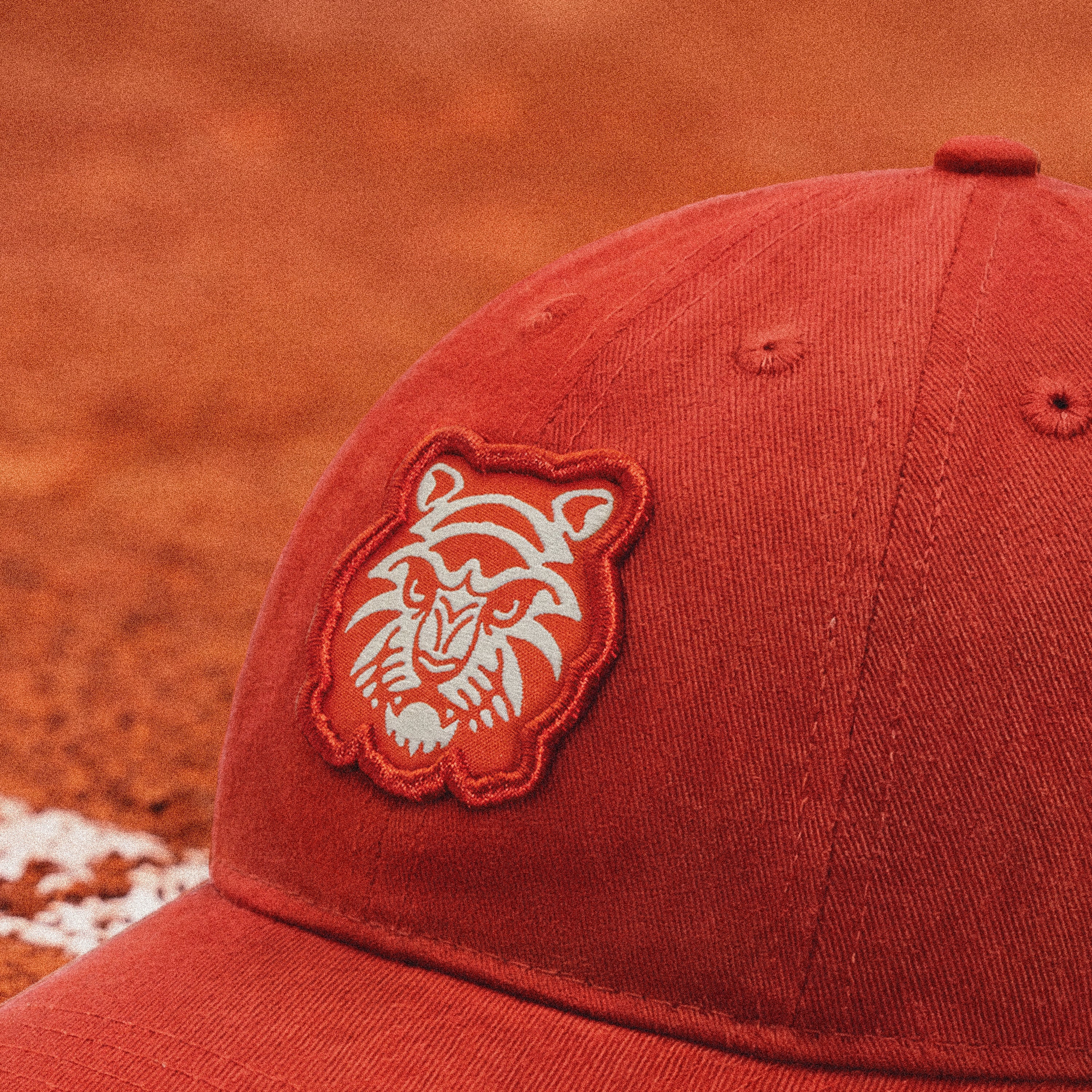 A raised embroidered Tiger patch anchors the front panel, finished in cream and tonal clay to blend into the court-inspired palette.
