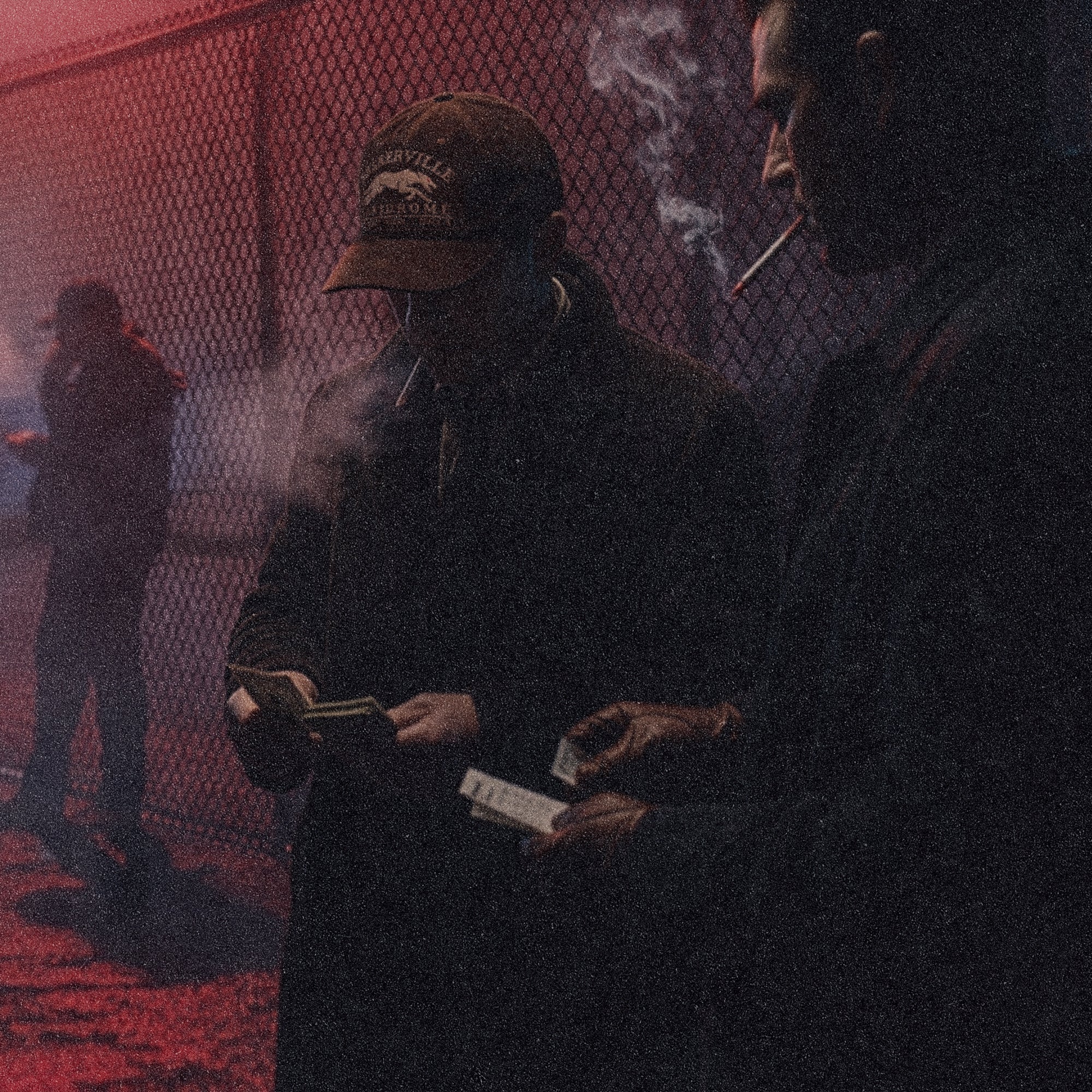 People wearing the Tigerclaw Baskerville Canidrome cap in a moody nighttime lifestyle campaign inspired by underground greyhound racing culture and vintage betting track aesthetics
