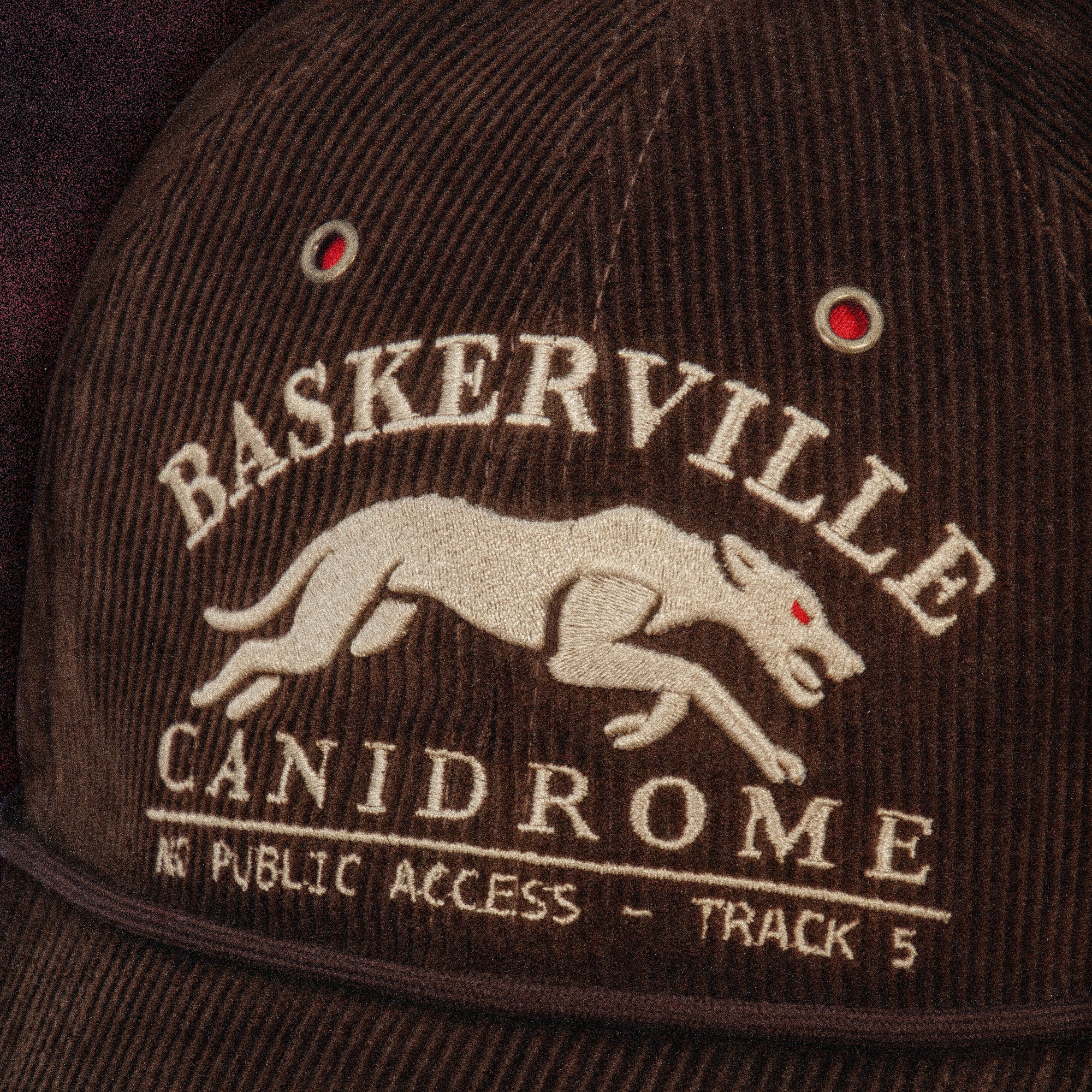 Close-up of the Tigerclaw Baskerville Canidrome corduroy cap featuring embroidered greyhound artwork, vintage racing graphics and premium headwear craftsmanship