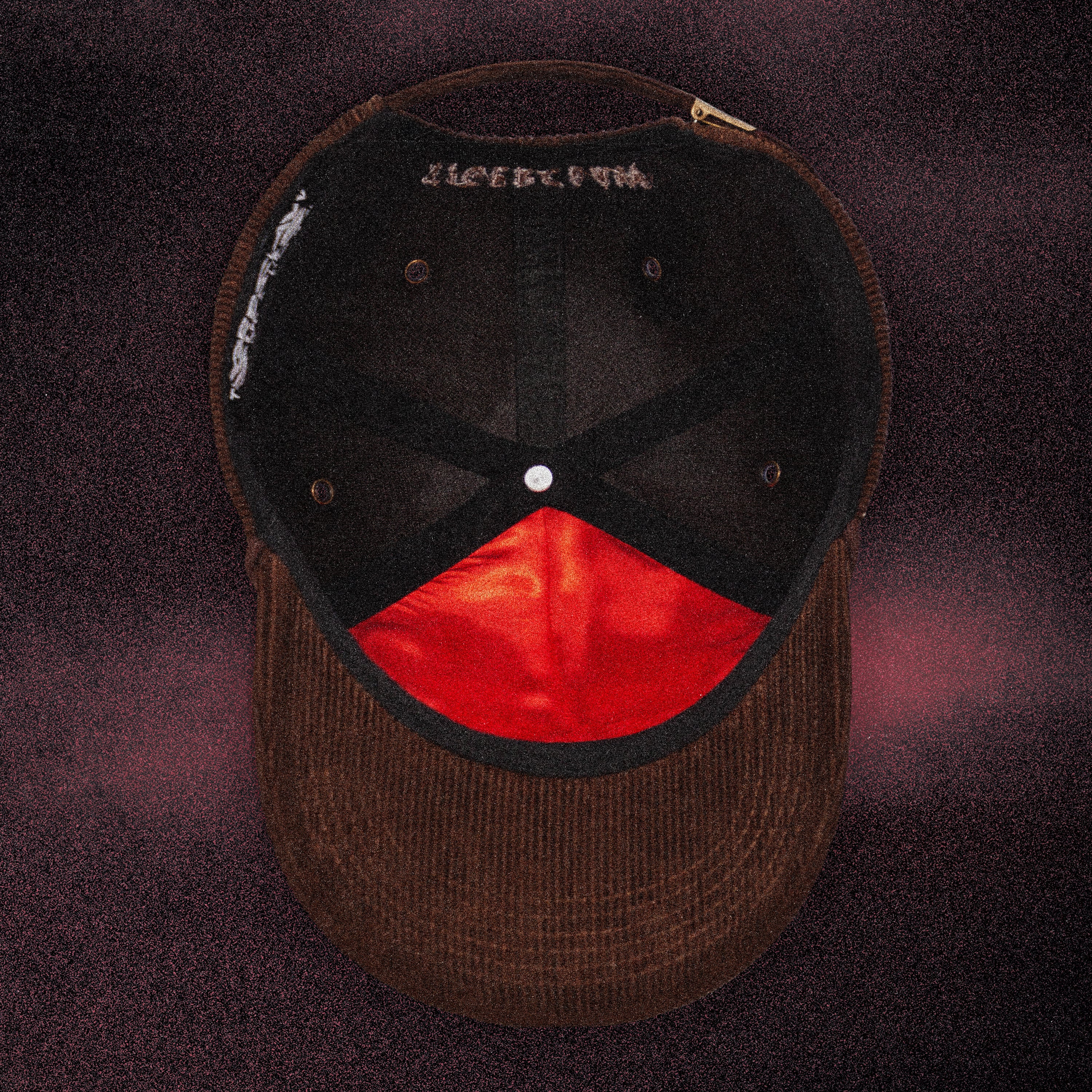 Top-down interior view of the Tigerclaw Baskerville Canidrome corduroy cap showcasing premium headwear construction, custom interior taping and signature red satin lining