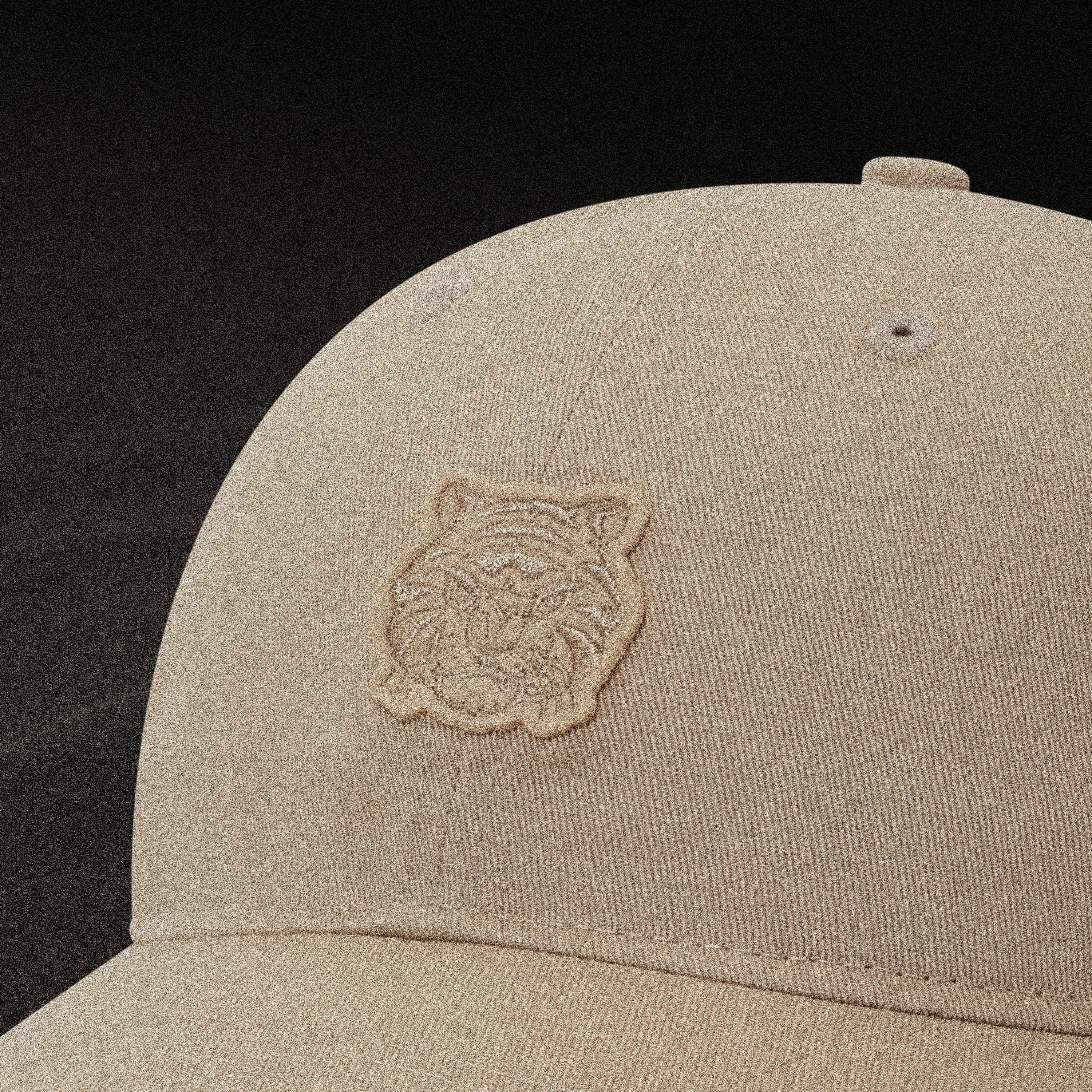Beige cap with a tiger logo on a black background