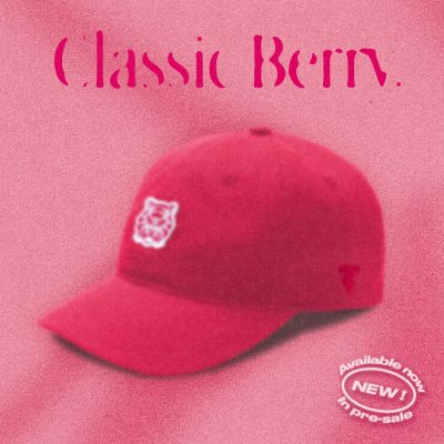 A red "Classic Berry" Tigerclaw strapback cap set against a matching pink-red background with bold serif text above and a circular "Available now" sticker in the corner.