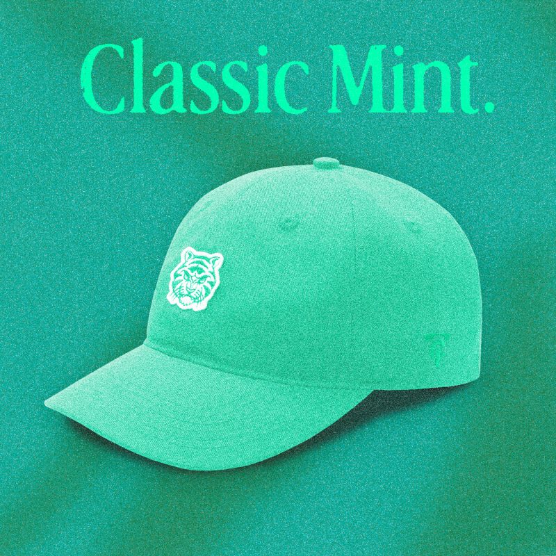 A mint green "Classic Mint" Tigerclaw strapback cap set against a textured mint-toned backdrop, with bold serif headline text above the cap and a clean front angle showcasing the white embroidered tiger logo.