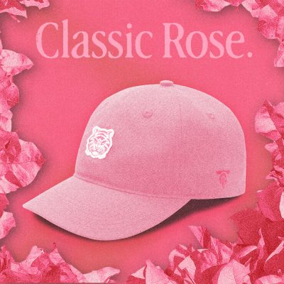 A soft pink "Classic Rose" Tigerclaw strapback cap positioned on a rose-colored gradient background, with serif “Classic Rose” text above and a white embroidered tiger logo on the front panel.