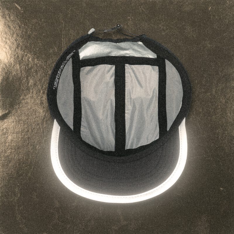 Top view of the Tigerclaw LUMEN8 running cap with reflective panels glowing under light.