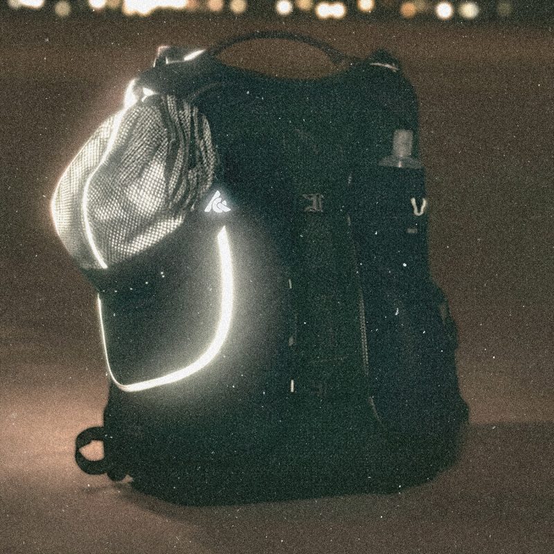 Tigerclaw LUMEN8 reflective running cap glowing at night, attached to a running backpack.